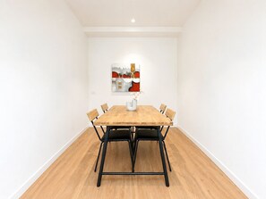A dining area with a wooden table, six chairs, and a vase with flowers. - Heart of Doncaster 1BR Apt with  Wi-FI Parking (Doncaster)