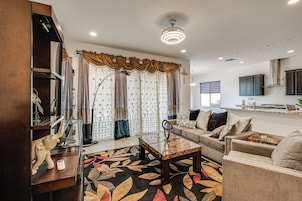 A modern living room with a glass coffee table, a sofa, and a decorative rug.
