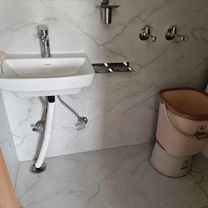 A bathroom with a white sink, a toilet, and a bidet. - COMFORT HOME STAY (Agra)