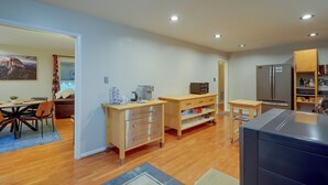 Moderni keittiö, jossa on puiset kaapit, jääkaappi ja mikroaaltouuni.