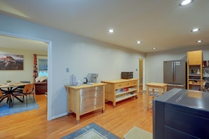 A modern kitchen with wooden cabinets, a refrigerator, and a microwave. - Fire Pit & Grill! Wooded Durham Retreat (Durham)