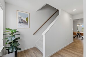 Ein modernes Interieur mit einer Treppe, einem gerahmten Stadtbild und einer Topfpflanze.