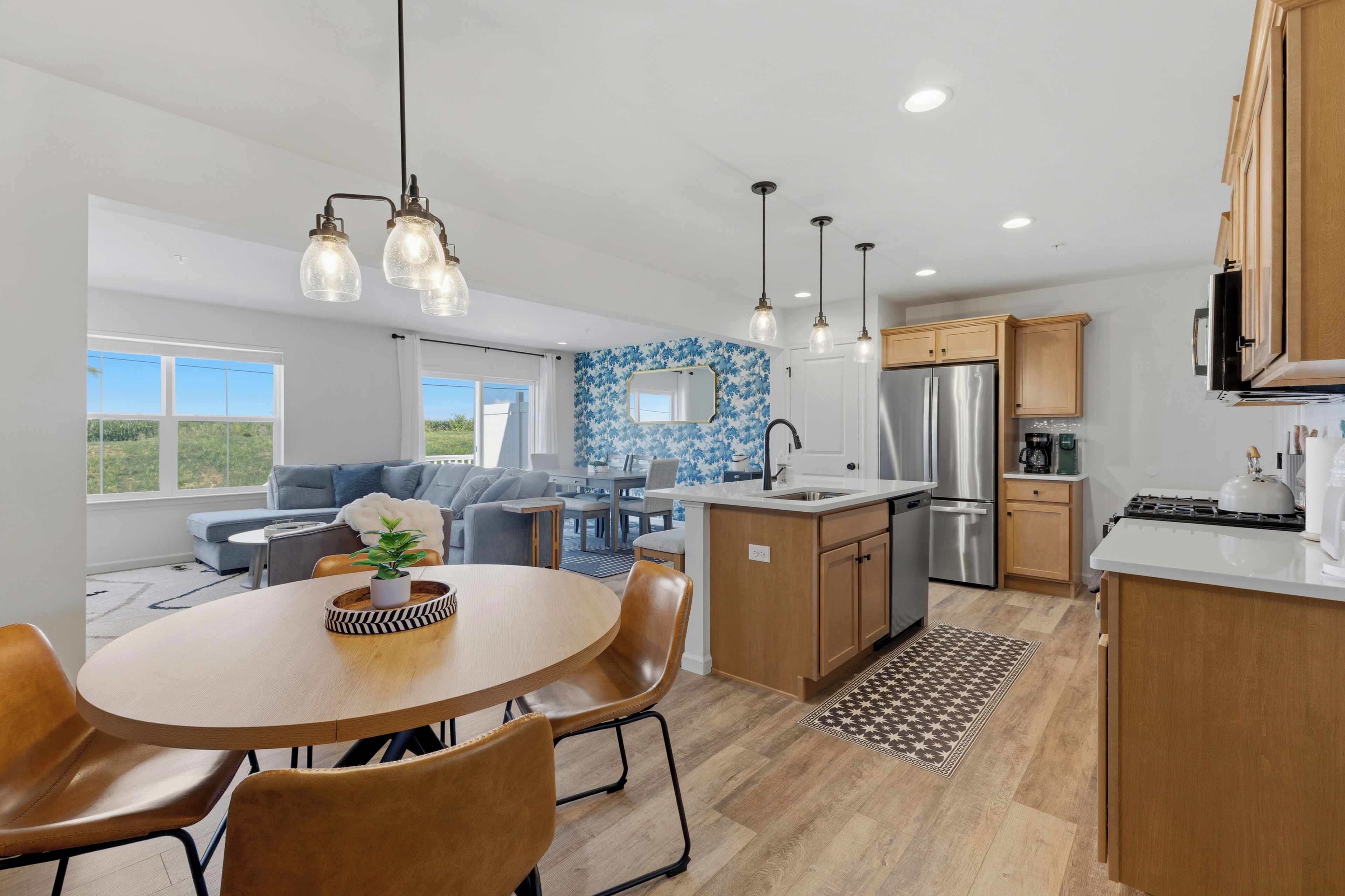 A modern kitchen with a central island, stainless steel appliances, and pendant lighting.