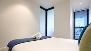 Una habitación de hotel con cama, ventana y vistas al exterior.