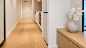 Una cocina moderna con armarios blancos, horno empotrado y refrigerador.