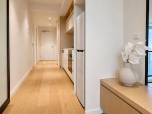 Eine moderne Küche mit weißen Schränken, einem eingebauten Backofen und einem Kühlschrank.