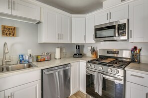 A modern kitchen with white cabinets, stainless steel appliances, and a coffee maker. - 5 Mi to Sdsu & Trails! Stylish Apartment w/ Patio (San Diego)