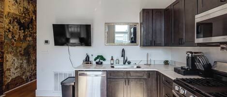 Una cucina moderna con elettrodomestici in acciaio inossidabile, forno a incasso e microonde.