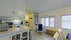 A compact kitchen with a gas stove, microwave, and cabinets. - 2 Decks & Pool Access: Ocean Pines Retreat (Berlin)