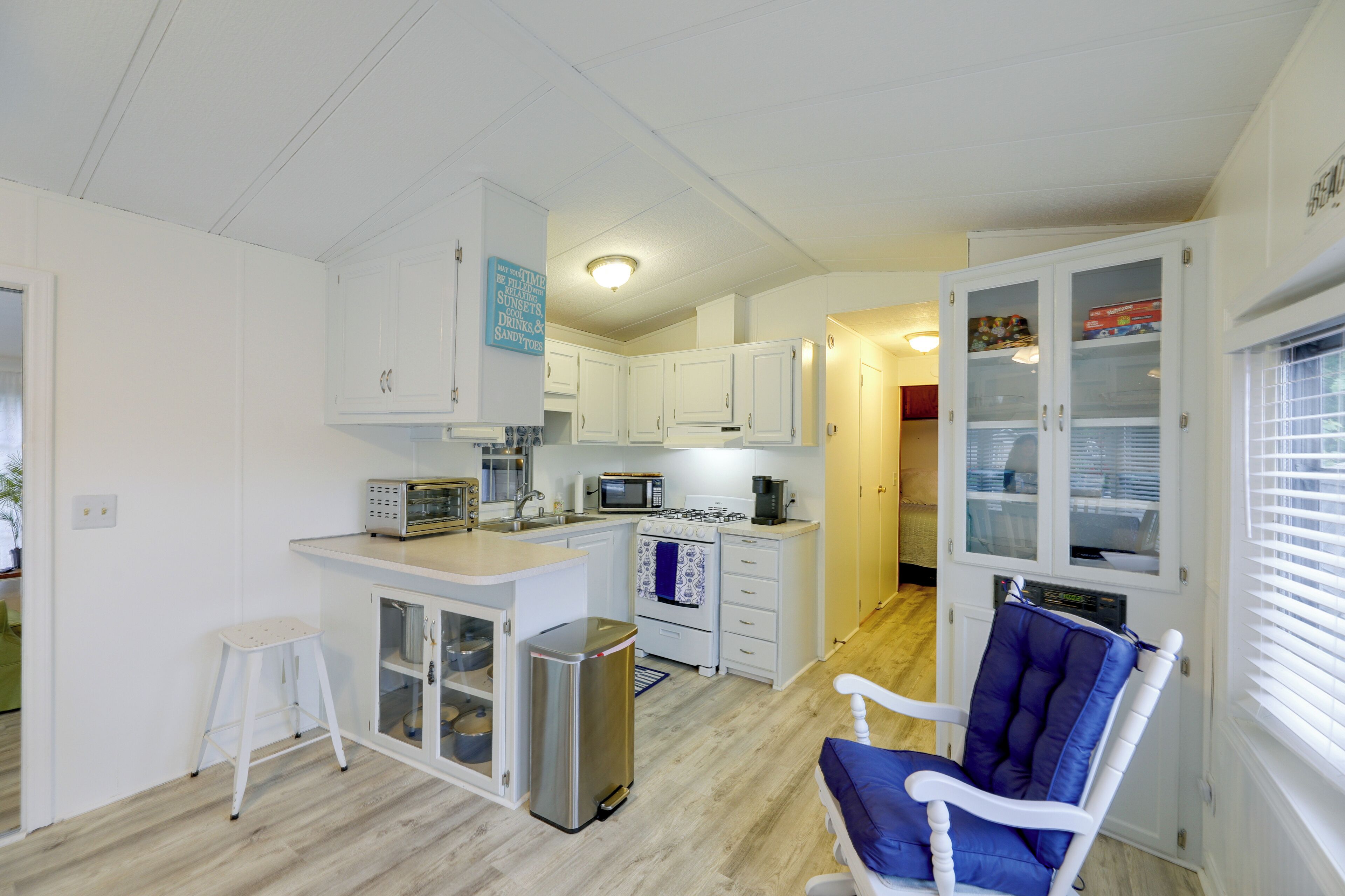 A compact kitchen with white cabinets, a built-in oven, a microwave, and a coffee maker.