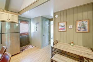 A kitchen with a refrigerator, a dining table, and a bench. - Steps to Lake! Cabin w/ Water Views in Hot Springs (Hot Springs)