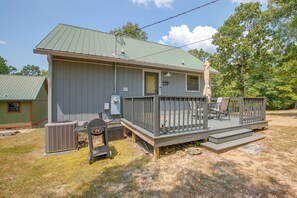 A single-story building with a green roof, a porch with a railing, and a small attached garage. - Steps to Lake! Cabin w/ Water Views in Hot Springs (Hot Springs)