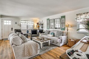 Un salon confortable avec un canapé, un fauteuil, une table basse et un téléviseur.