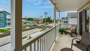A covered porch with a view of a street, a chair, and a potted plant. - Walk to Beach & Marinas! Brigantine 2-unit Duplex (Brigantine)