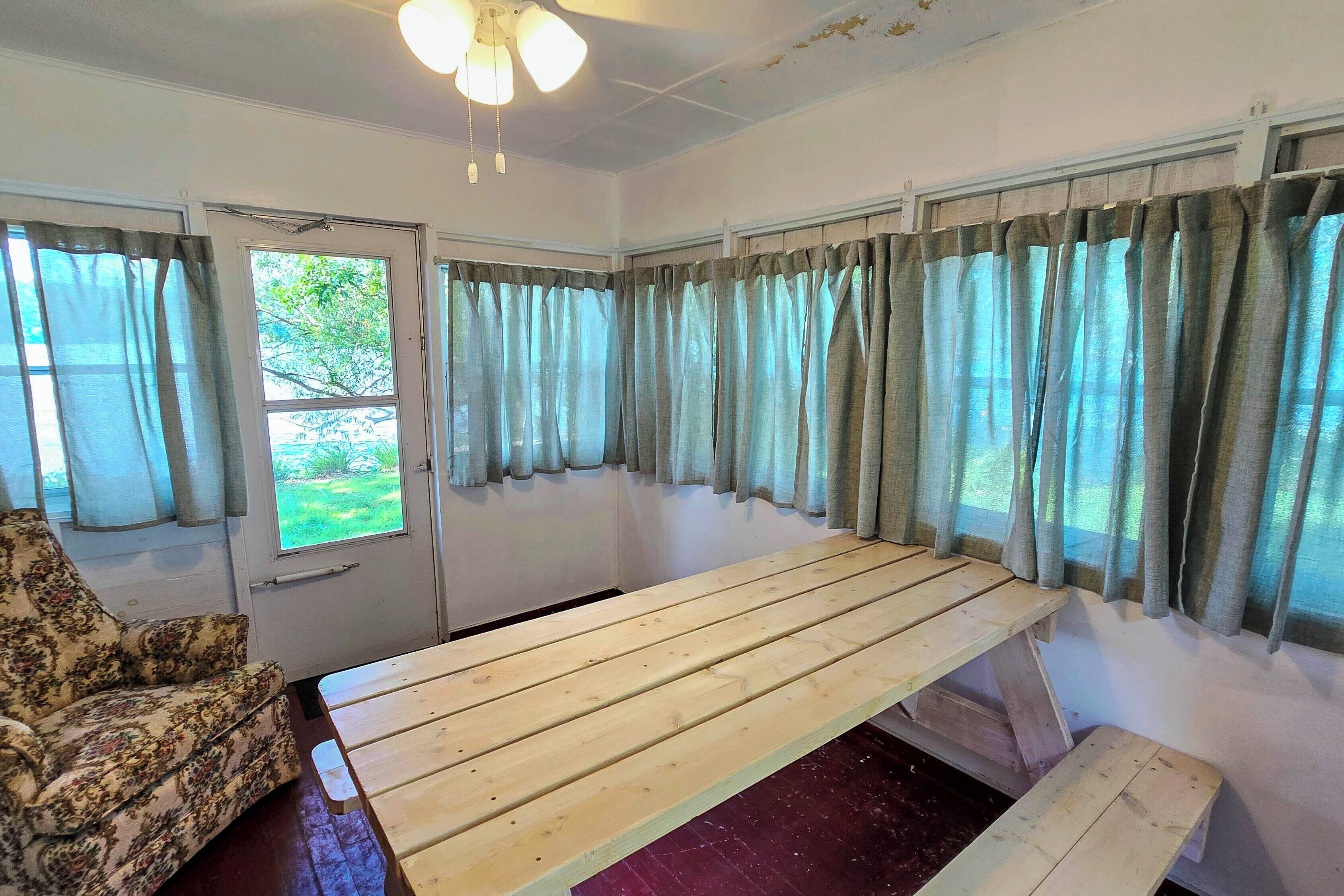 A room with a wooden bench, a patterned armchair, and a door leading outside.