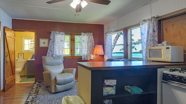 A compact kitchen with a ceiling fan, a microwave, and a stove. - Pet-friendly Rustic Cabin Steps From Lake Chetek (Chetek)