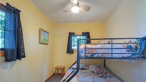 A dormitory room with bunk beds, a ceiling fan, a small wooden stool, and a framed picture on the wall. - Pet-friendly Rustic Cabin Steps From Lake Chetek (Chetek)