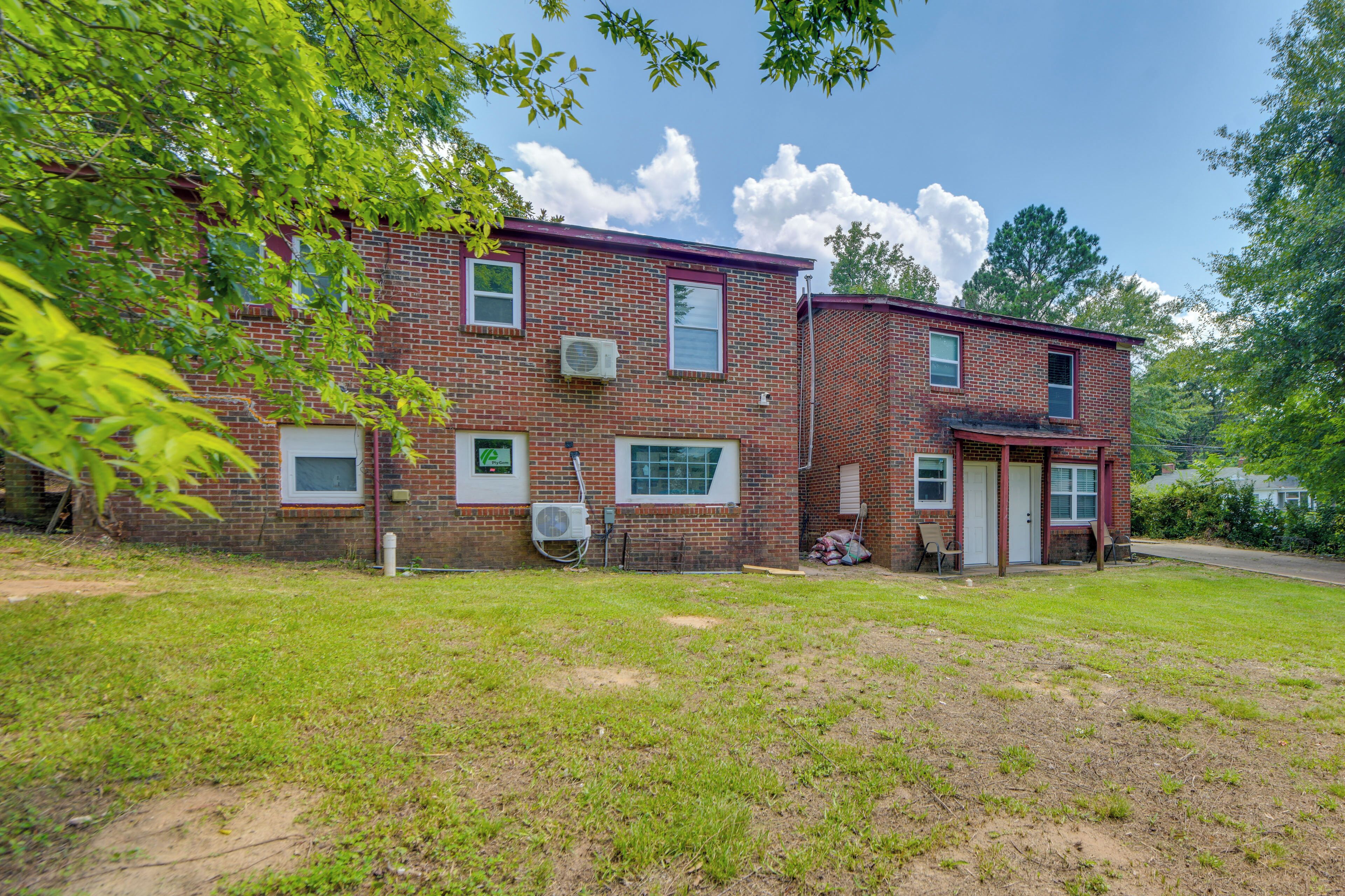 A two-story brick building with a front yard, a garage, and a driveway.