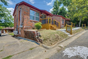 A two-story brick house with a red roof, a front porch with a wooden staircase, and a small front yard. - Walk to Historic Dtwn Tuskegee! Apt w/ Shared Yard (Tuskegee)