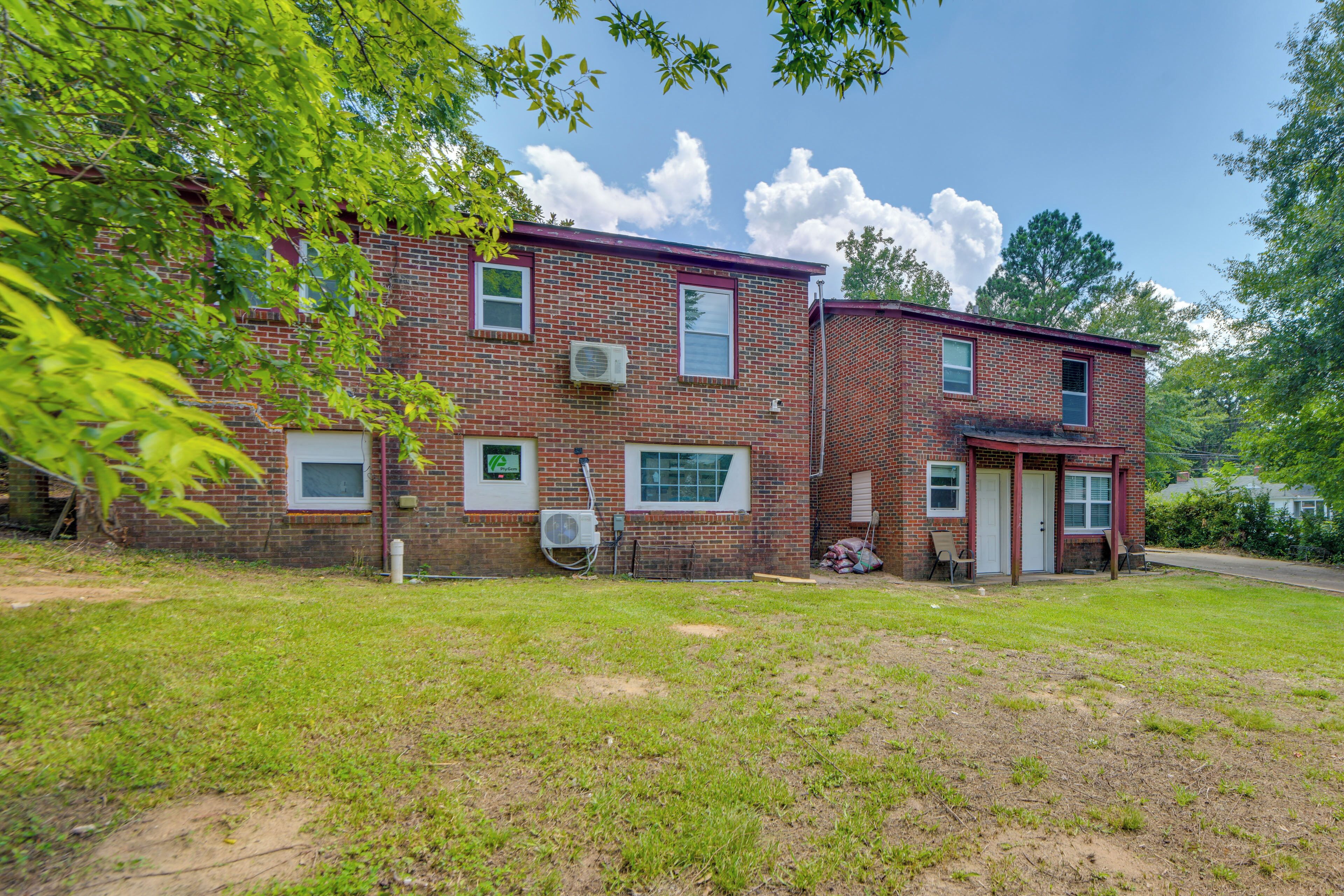 A two-story brick building with multiple windows and an air conditioning unit.