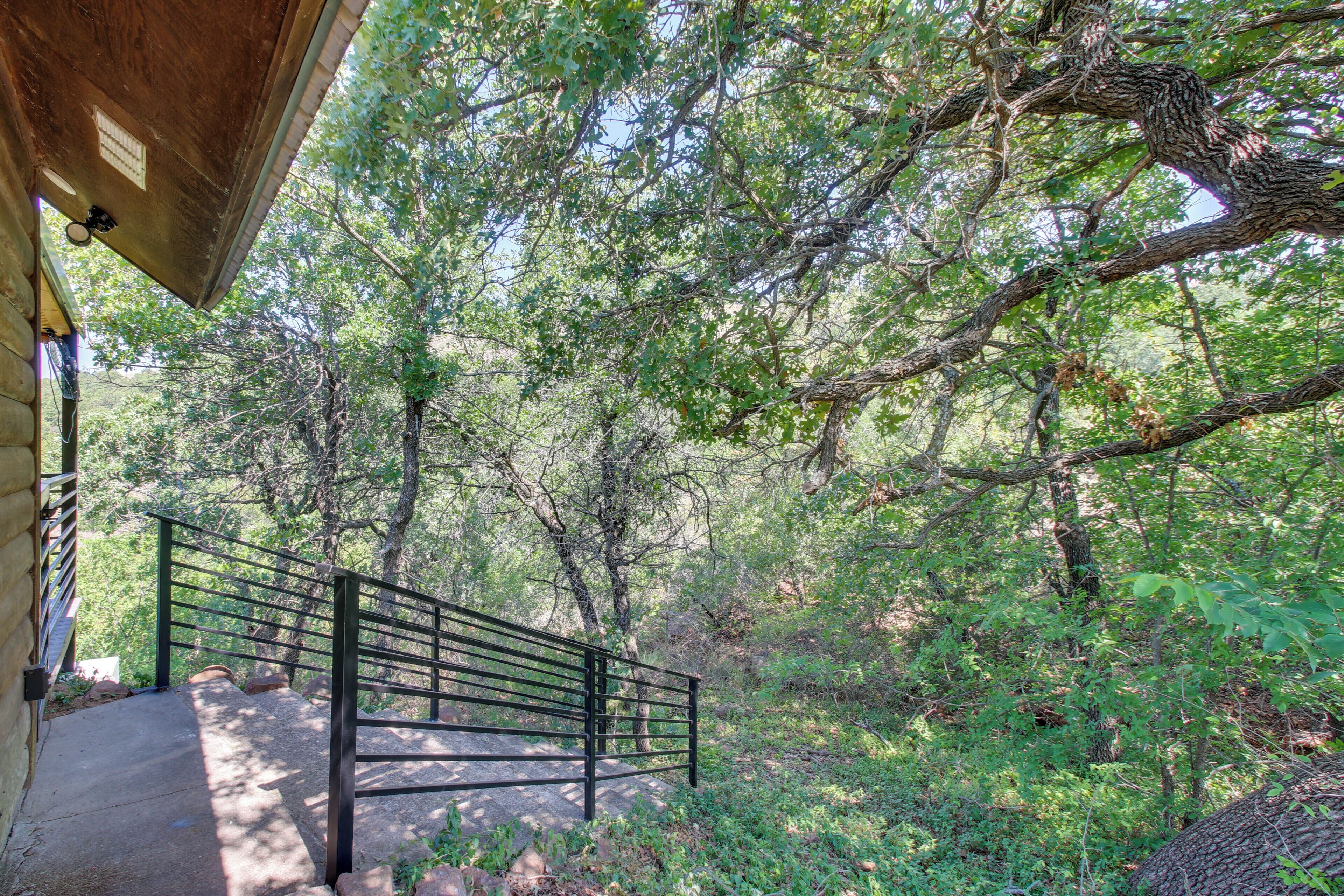 A pathway with a metal railing leading through a wooded area.