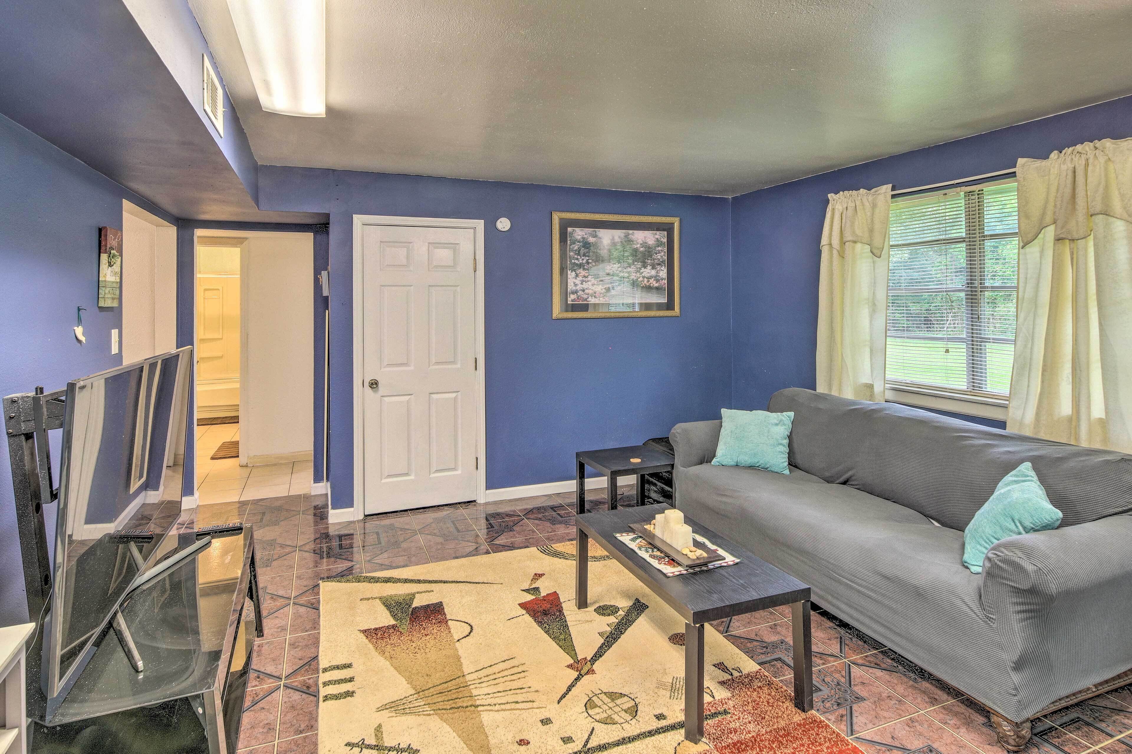 A living room with a gray sofa, a coffee table, and a patterned rug.
