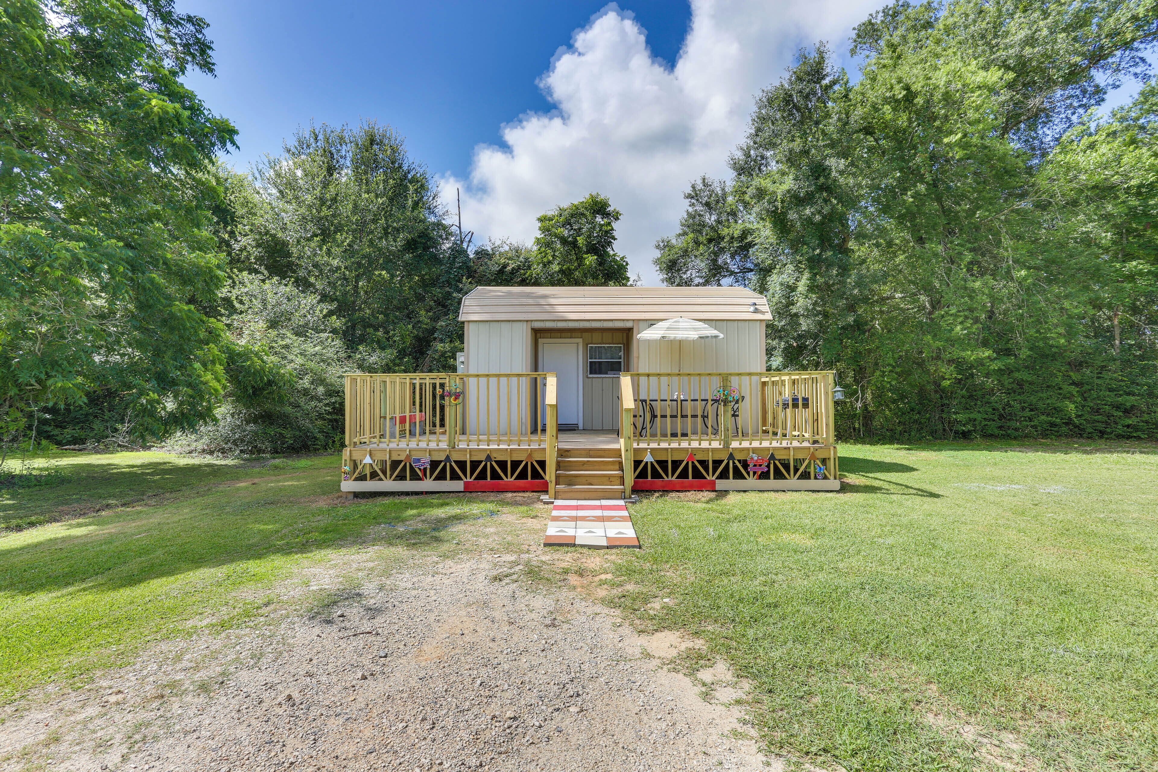 A small, single-story cabin with a porch, a door, and a window.