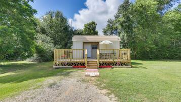 A small, single-story cabin with a porch, a door, and a window.