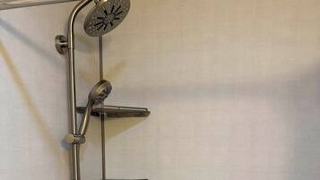 A shower with a handheld showerhead and a fixed rain showerhead.