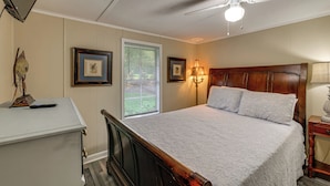 A bedroom with a bed, a desk, a ceiling fan, and a window with blinds. - Dock & Outdoor Bar! Lake Blackshear Getaway (Cobb)