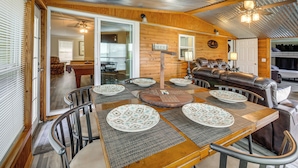 A cozy interior with a dining area, a sofa, and a bunk bed. - Dock & Outdoor Bar! Lake Blackshear Getaway (Cobb)