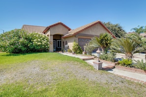A residential house with a tiled roof, a front entrance, and a well-maintained lawn.