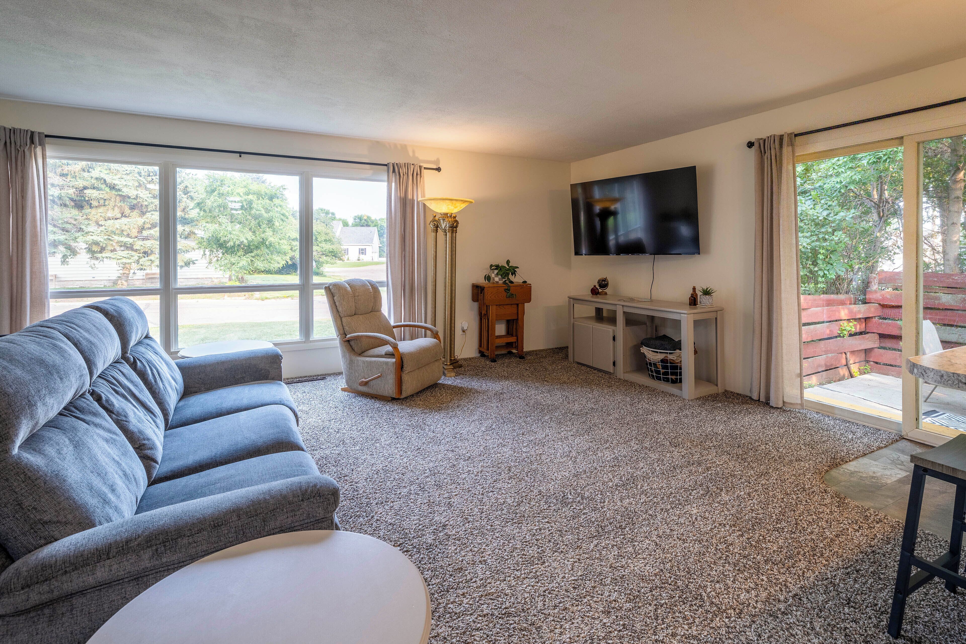A living room with a sofa, a chair, a TV, and a small table.