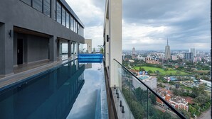 A modern building with a pool and a view of a cityscape. - Stylish Studio apartment Upperhill｜Pool & Gym (Nairobi)