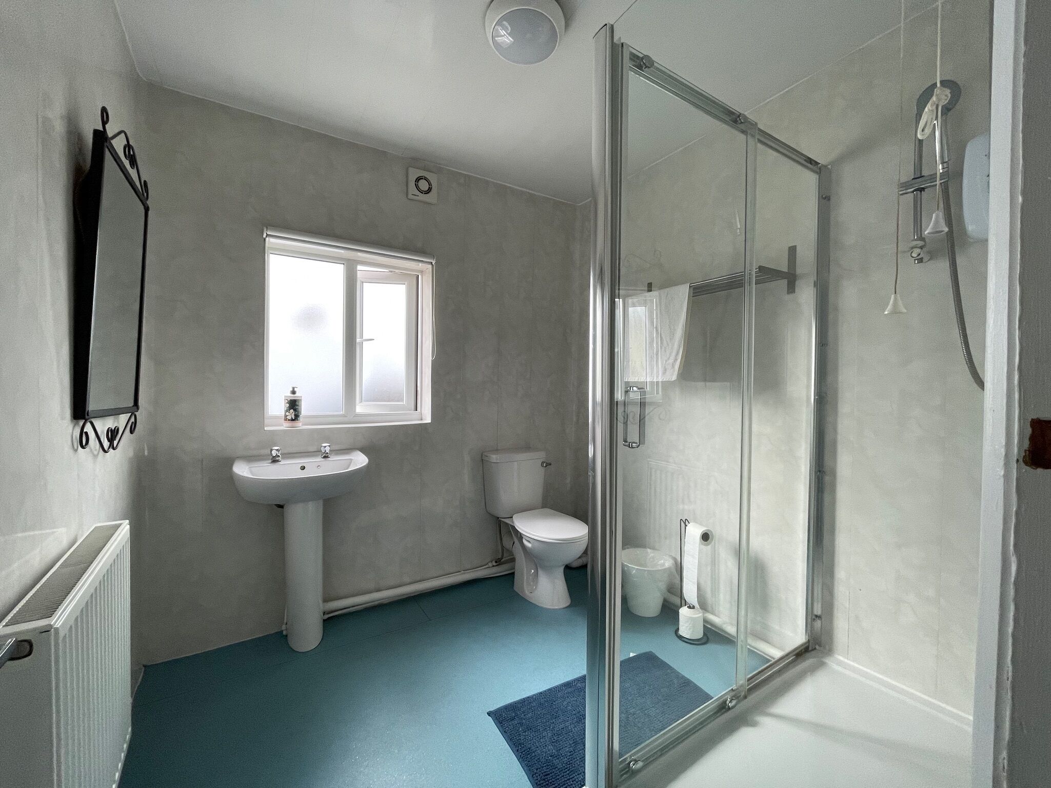 Une salle de bain avec une douche à parois de verre, un lavabo et des toilettes.