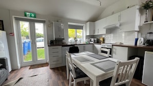 A compact kitchen with a dining table, chairs, a microwave, and a stove.