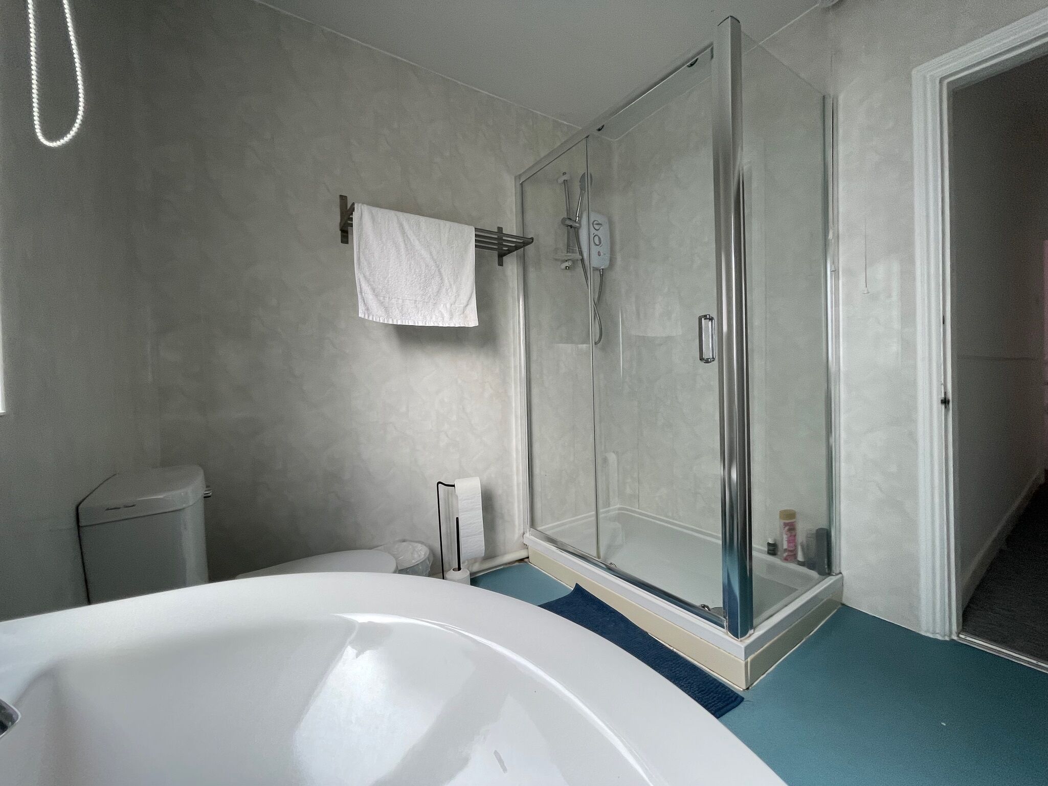 A bathroom with a bathtub, a glass-enclosed shower, and a toilet.