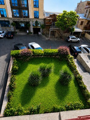 Un hôtel doté d’un parking, d’un espace paysager verdoyant avec des plantes et d’un bâtiment avec de nombreuses fenêtres.