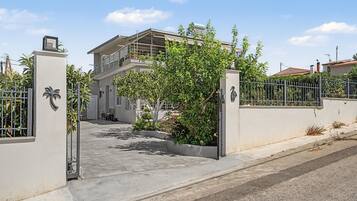 A gated entrance to a residential property with a balcony and a covered outdoor area.