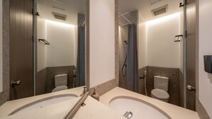 A bathroom with two sinks, a shower, and a toilet. - Cove Svasa (Jakarta)