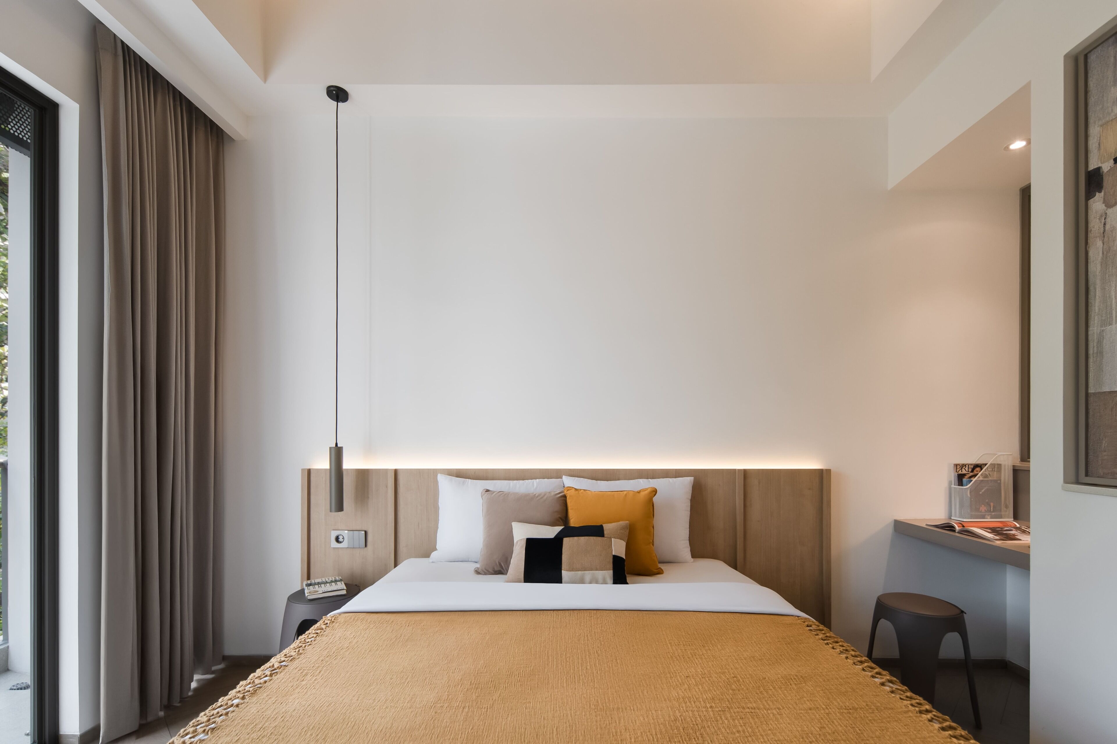 Een moderne hotelkamer met een groot bed, een nachtkastje, een bureau en een stoel.