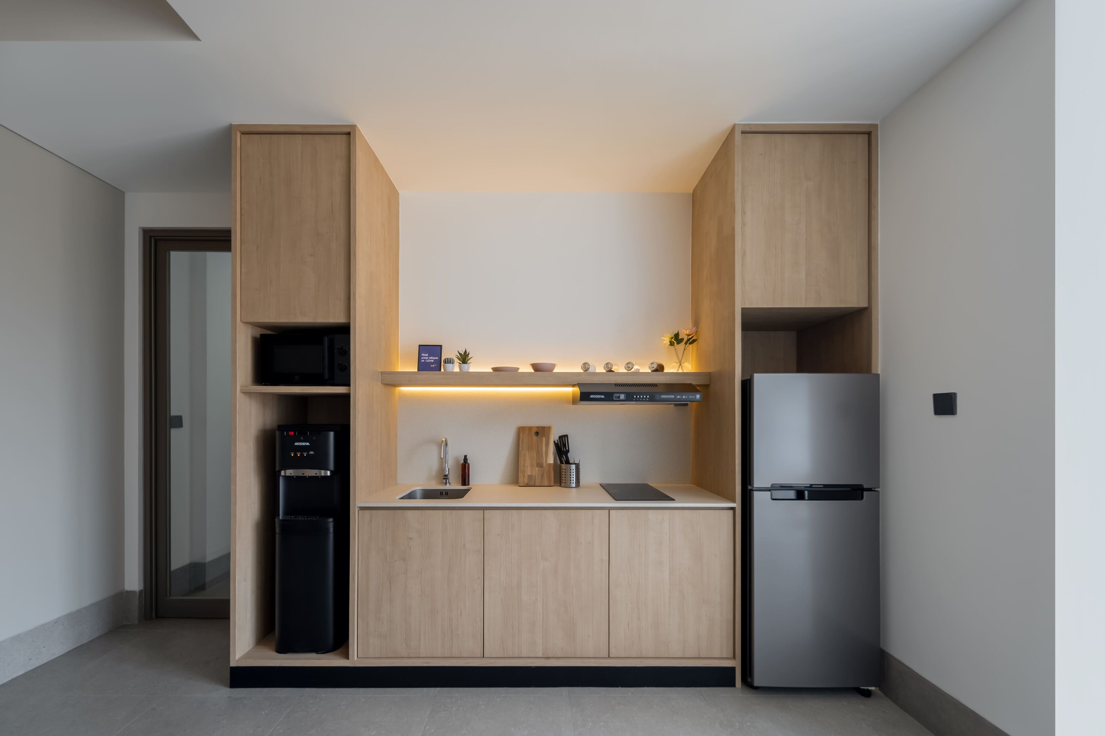 A modern kitchen with built-in appliances, wooden cabinets, and a stainless steel refrigerator.