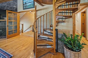 A wooden spiral staircase with a handrail and a landing area. - S7610 | 10 Deschutes (Sunriver)
