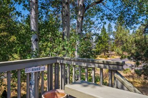 A wooden deck with a sign pointing towards a river. - S7610 | 10 Deschutes (Sunriver)