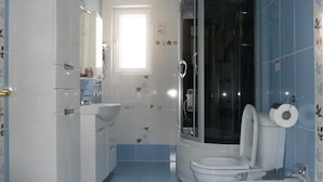 Un baño con ducha, inodoro, bidé y lavabo.