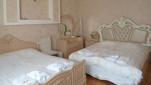Habitación de hotel con dos camas, cómoda, espejo y candelabro.