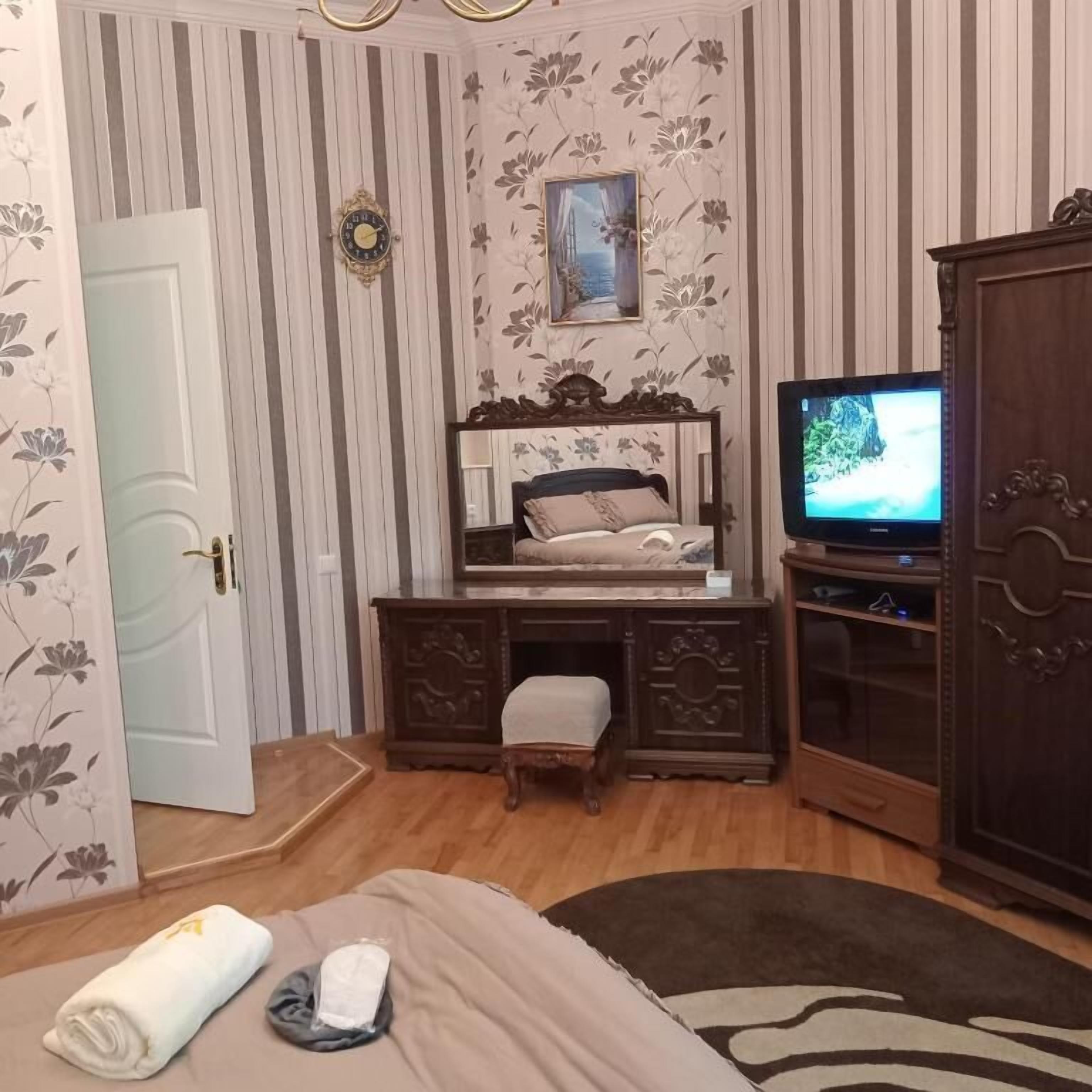Une chambre d’hôtel équipée d’un lit, d’un bureau, d’une télévision et d’une armoire.