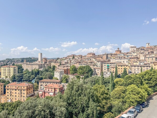 Un paysage urbain dense, caractérisé par des bâtiments historiques, une tour imposante et un mélange de constructions résidentielles et commerciales.