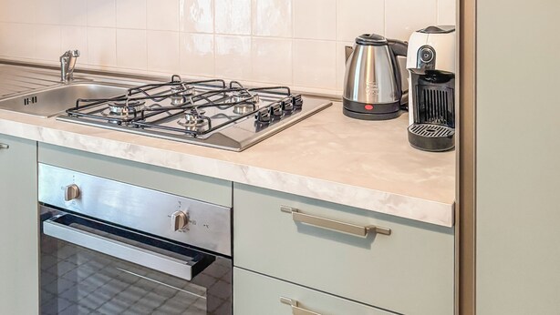 A kitchen with a gas stove, oven, and modern appliances.