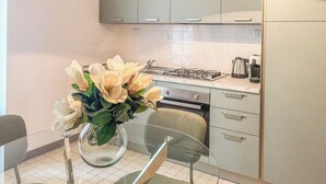 A modern kitchen with grey cabinets, a gas stove, and a coffee maker. - Maison Panorama (Perugia)